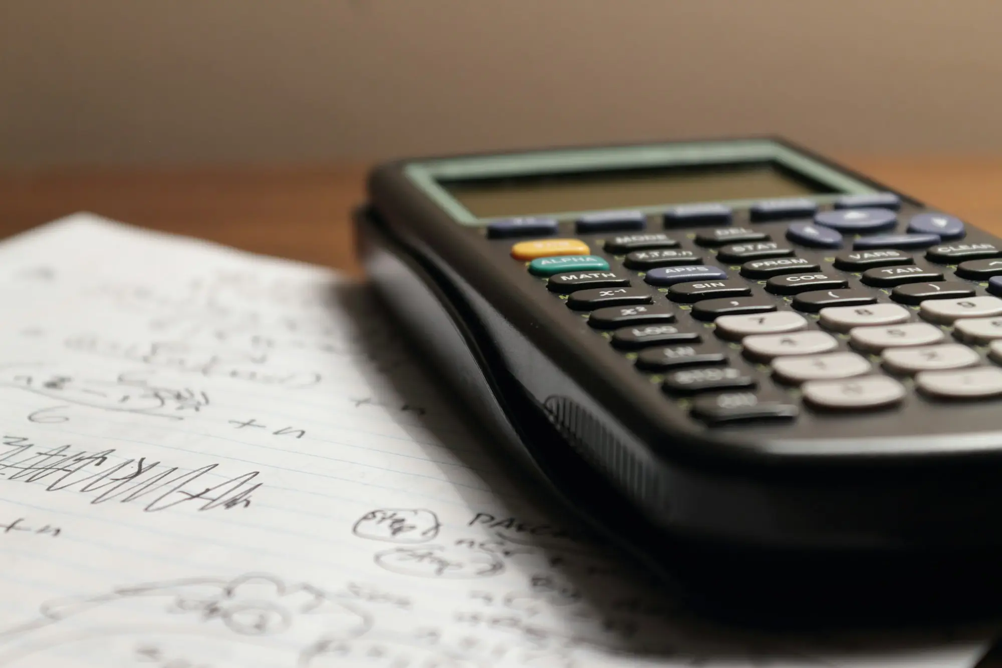 Calculator resting on a handwritten loan comparison
