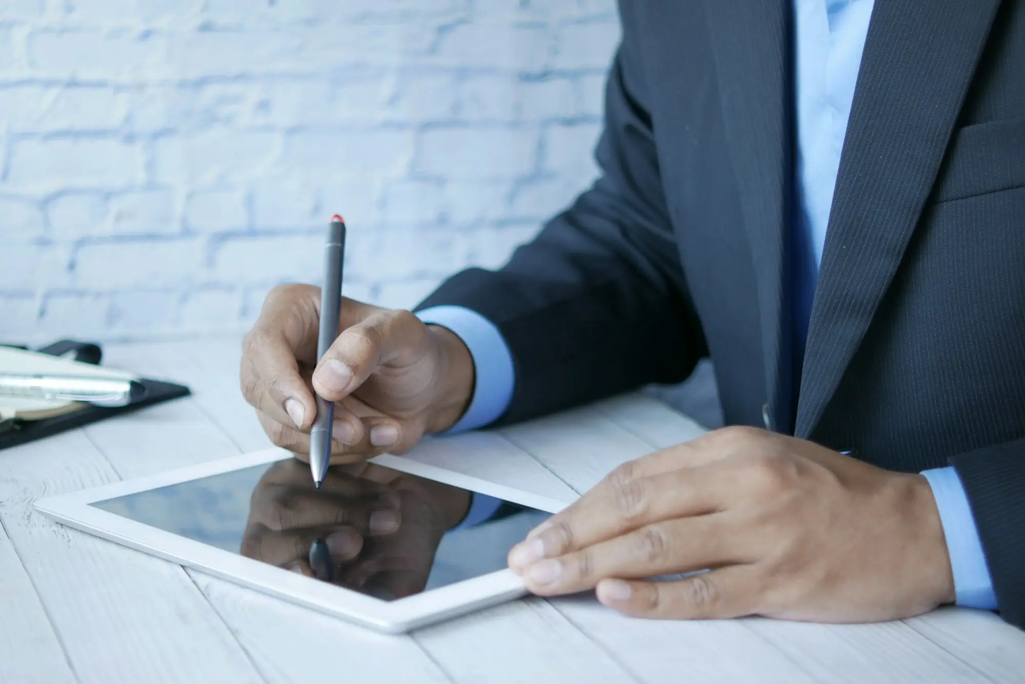 Business owner signing on a tablet for settlement day